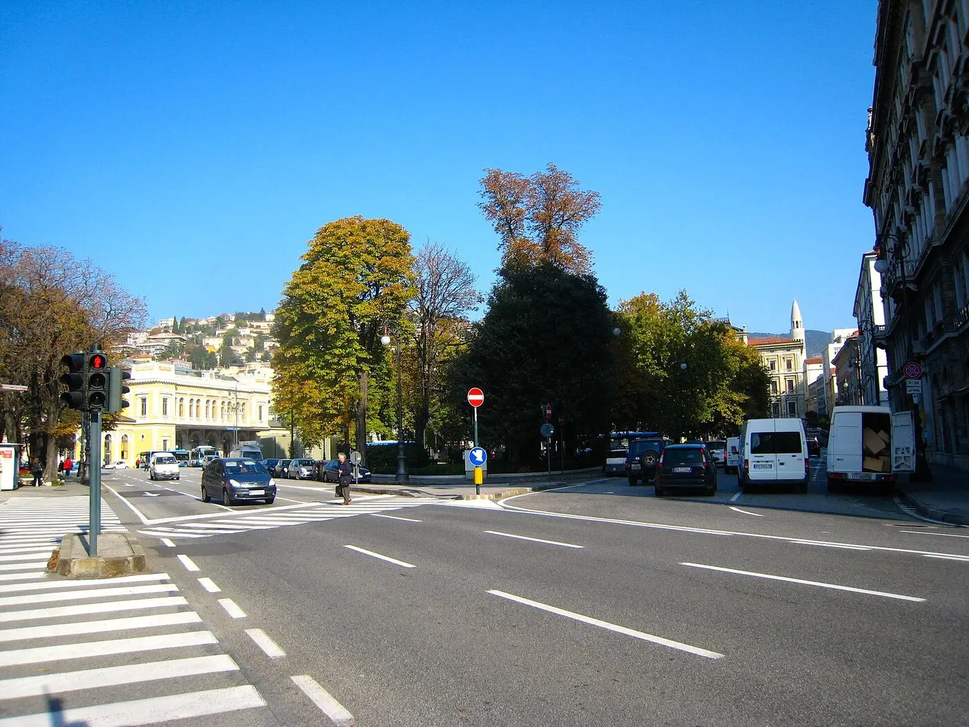资料图:的里雅斯特自由广场(piazza Libertà),左侧黄色建筑为中央火车站(图:Tiesse / Wikimedia Commons,CC0,2009 年 10 月摄,非事发现场照片)