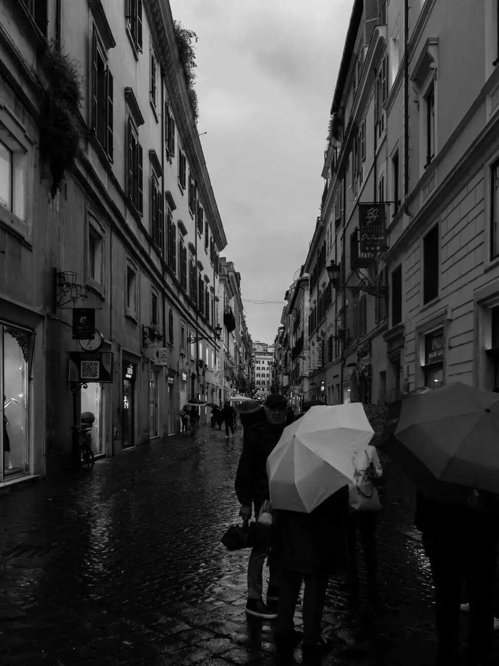 示意图:雨天撑伞走在罗马石板街上的行人(图库照片,Alejandro Aznar / Pexels,资料图,非本次预警现场)